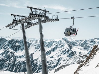 Ausflugsziele in Sölden gesucht? Seilbahn über verschneiten Bergen mit großen Stützen