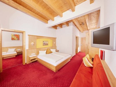 Family hotel in Sölden: Hotel Sunny Sölden Hotel room with double bed, single room, red carpet, and wooden beam ceiling