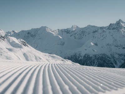 Ausflugsziele in Sölden gesucht? Präparierte Skipiste vor verschneiter Berglandschaft